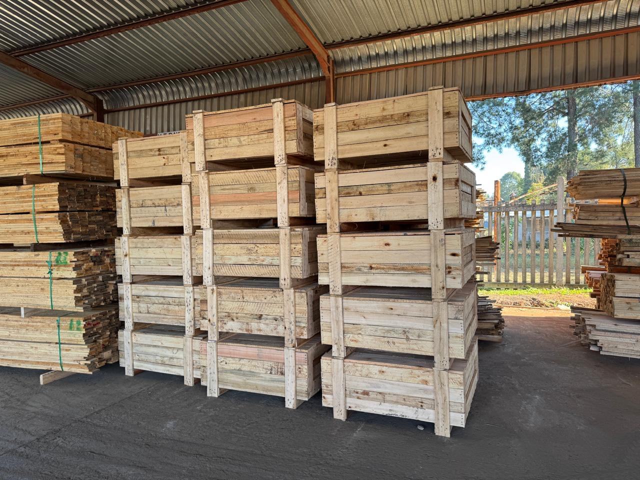 Open slatted wooden crates stacked under a roof